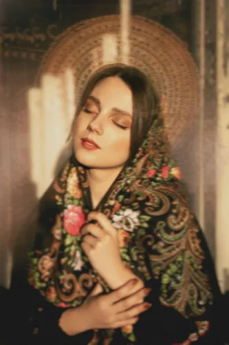 photo of young woman in kerchief on head pretending saint