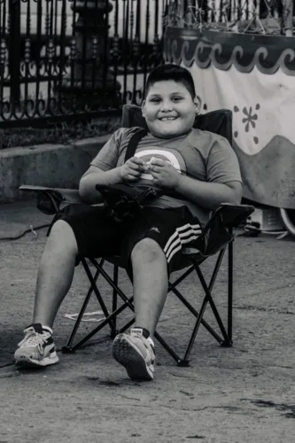 a boy sitting in a chair with a ball
